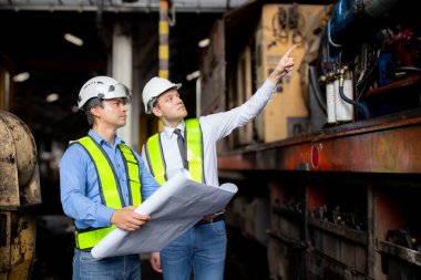 Kafkasyalı genç mühendis, tren planlarını kontrol ediyor. Ekip mühendisi, sistem ulaşımını denetliyor. Teknisyen, altyapı, ulaşım ve endüstri kavramını inceliyor..
