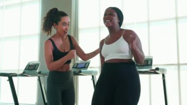 Spor salonunda ısınan ve kaslarını esneten antrenman yapan antrenör ya da eğitmen kadın spor salonunda spor yapan kadın spor antrenörü, spor ve sağlık motivasyonu ile spor yapıyor..