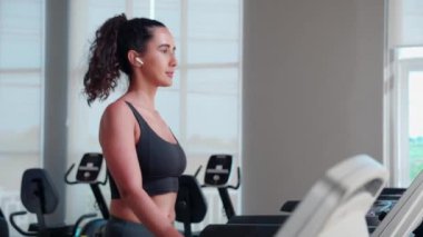 Genç kadın spor salonunda yürüyüş ve egzersiz makinesinde spor yapıyor. Kardiyo eğitimli kadın sporu, sağlık ve motivasyon, güç için eğlence ve sağlık..