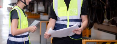 Kafkasyalı genç mühendis ve kadın ya da işçi istasyon, ulaştırma ve altyapı, müfettiş ya da teknisyen kontrolleri için planlı ve elektrikli trenin bakımını kontrol ediyor..
