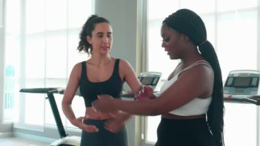 Spor salonunda ısınan ve kaslarını esneten antrenman yapan antrenör ya da eğitmen kadın spor salonunda spor yapan kadın spor antrenörü, spor ve sağlık motivasyonu ile spor yapıyor..