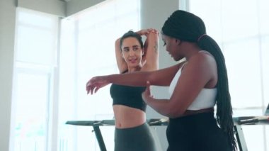 Spor salonunda ısınan ve kaslarını esneten antrenman yapan antrenör ya da eğitmen kadın spor salonunda spor yapan kadın spor antrenörü, spor ve sağlık motivasyonu ile spor yapıyor..