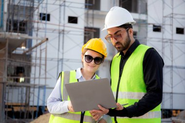 İnşaat sahasında teftiş ve planlama için dizüstü bilgisayar arayan mimar ya da mühendis ekibi, proje geliştirme evini inceleyen ve kontrol eden müteahhit ya da müteahhit, sanayi konsepti.