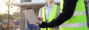 İnşaat sahasında teftiş ve planlama için dizüstü bilgisayar arayan mimar ya da mühendis ekibi, proje geliştirme evini inceleyen ve kontrol eden müteahhit ya da müteahhit, sanayi konsepti.