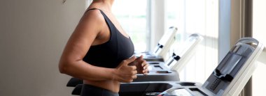 Genç kadın spor yaparken spor yapıyor ve spor yaparken koşu bandında egzersiz yapıyor. Kardiyo eğitimli kadın sporu, sağlık ve motivasyon, güç için boş zaman ve sağlık..