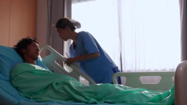 Genç Asyalı hemşire, hastanede ya da klinikte hasta bakımı ve yardım, erkek hasta, sağlık ve sigorta ile dikkatlice ilgilenir..