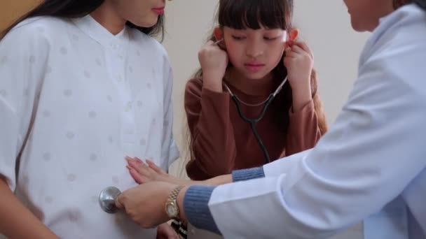 亚洲女儿使用听诊器与母亲一起听婴儿的心跳 而医生则在医院 怀孕和医疗 怀孕和保健 怀孕期间的家庭和保健 — 图库视频影像