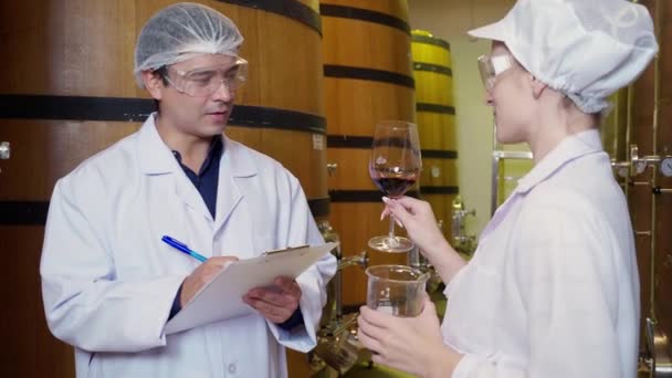 ワインメーカーのチームは 工場のワイナリーでワインの生産をチェックし 検査し 品質をチェックし 室内のタンクやバレルでワインの貯蔵を発酵する検査官 産業および製造コンセプト — ストック動画