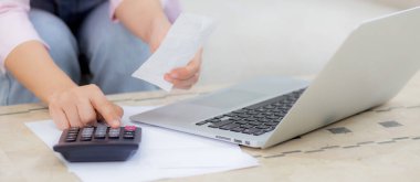 Mali ev işlerini evde hesap makinesiyle hesaplayan kadının elleri, tasarruf ve planlama masrafları, borç ve kredi, vergi ve muhasebe, iş ve mali işler için faturaları kontrol eden kız.