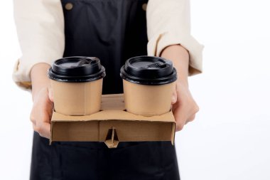 Barista 'lı genç Asyalı bir kadının önlüklü hali hazır kahve fincanını sunuyor, elleri izole edilmiş beyaz arka plana odaklanıyor, kahve barmeninin elinde tek kullanımlık kahve fincanı, küçük işletme ya da yeni başlayanlar..
