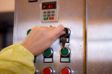 Teknisyen genç kadın fabrikadaki kontrol panelini optimal performans, endüstriyel makine ve işçi veya mühendis, kadın düğmeye basma mekanizması, dikiz penceresi, sanayi konsepti.