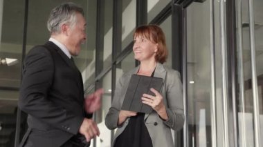 Resmi toplantıda iki kıdemli işadamı ve kadın belgeleri tartışıyor ve modern ofiste bir tablet kullanılıyor, iş ortağı veya danışmanlık ile iş adamı planlaması, iş ve takım konsepti.