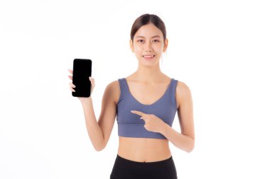 Spor giyinen genç Asyalı kadın spor kıyafetlerini tutuyor ve boş ekran akıllı telefonu sunuyor. Beyaz arka plan izole edilmiş, spor giyimli kız akıllı telefon, spor ve sağlık hizmetleri konsepti gösteriyor..