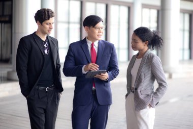 Grup genç iş adamı ve kadın belgeleri modern bir ofiste bir tablette buluşup tartışıyor, ortakla veya danışmanlıkla iş adamı planlama, takım çalışması ve meslektaşlar, iş ve takım konsepti.