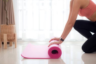 Matta yogası ile yere yuvarlanan genç bayanın elleri evde meditasyon hazırlığı ve dinlenme egzersizi için egzersiz, egzersiz ve sağlık için aktivite ve hobilerle yoga yapıyor..