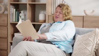 Yaşlı, beyaz bir kadın kanepede oturmuş kitap okuyor. Oturma odasında rahatsız bir şekilde boyun ağrısı çekiyor. Son sınıf öğrencisi, rahatsız ve bıkkın bir şekilde kitap okuyor..