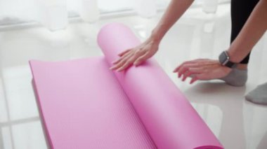 Matta yogası ile yere yuvarlanan genç bayanın elleri evde meditasyon hazırlığı ve dinlenme egzersizi için egzersiz, egzersiz ve sağlık için aktivite ve hobilerle yoga yapıyor..