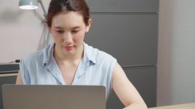 Young caucasian woman sitting and using laptop computer planning for success in modern office, businesswoman typing and watching notebook with confident, employee working on desk, business concept.
