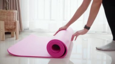 Matta yogası ile yere yuvarlanan genç bayanın elleri evde meditasyon hazırlığı ve dinlenme egzersizi için egzersiz, egzersiz ve sağlık için aktivite ve hobilerle yoga yapıyor..