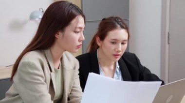 İki iş kadını proje üzerinde çalışırken modern ofiste evrak işleri, mali ve toplantı, iş ve pazarlama hakkında planlama ve strateji yapan iki iş kadını,.