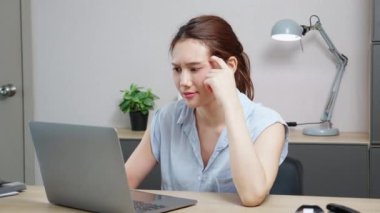 Genç Kafkasyalı iş kadını bilgisayarını kullanırken modern ev ofisinde başarı fikrini düşünüyor. Tablet jesti ile çalışan iş kadını evde, iş yerinde ve serbest oturma odasında olmaktan memnun..