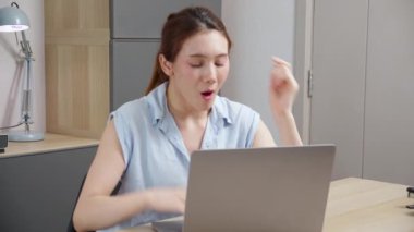 Genç Kafkasyalı iş kadını bilgisayarını kullanırken modern ev ofisinde başarı fikrini düşünüyor. Tablet jesti ile çalışan iş kadını evde, iş yerinde ve serbest oturma odasında olmaktan memnun..