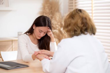 Genç Asyalı kadın terapisi modern tıp bürosunda kıdemli doktora danışmanlık, terapi, sağlık, sigorta ve sağlığı teşvik, stres ve depresyonlu hastalarla doktorluk danışmanlığı.