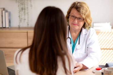 Yaşlıları muayene eden kıdemli doktor nabız yoklarken modern tıp bürosunda oturuyor, doktor kontrollü hasta, hasta ve sigorta, sağlık ve doktor hastalarla tartışıyor..