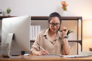 Çalışma odasındaki masaüstü bilgisayarına yazı yazarken mutlu genç iş kadını, bilgisayar kullanan iş kadını, girişimci ya da serbest çalışan, iş ve ticaret..