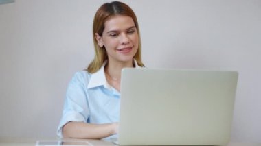 Genç iş kadınının ev ofisinin oturma odasında dizüstü bilgisayar kullanması, iş kadınının internet, girişimci ya da serbest çalışma, iş ve iletişim için dizüstü bilgisayar kullanması.