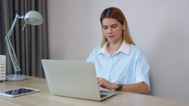 Genç iş kadınının ev ofisinin oturma odasında dizüstü bilgisayar kullanması, iş kadınının internet, girişimci ya da serbest çalışma, iş ve iletişim için dizüstü bilgisayar kullanması.