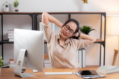 Genç Asyalı gözlüklü iş kadını portresi ev ofisindeki oturma odasında çok çalıştıktan sonra dinleniyor. İş kadını ergonomik, iş ve sağlık sorunları ile rahatlıyor..