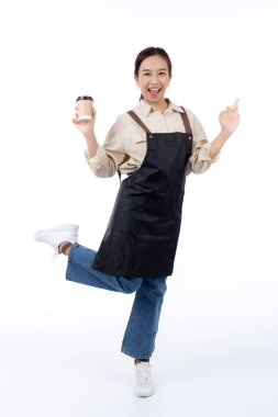 Genç Asyalı kadın barista elinde bir kahve fincanı ile heyecanlı bir jest yapıyor tamam izole edilmiş beyaz bir arka plan, mutlu bir barista başarıyla hazır kahveyi sunuyor, küçük işletmeler ya da yeni başlayanlar.