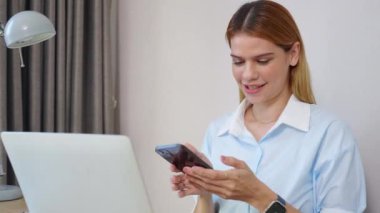 Kafkasyalı genç iş kadını akıllı telefonla konuşuyor ve ofisteki dizüstü bilgisayarda çalışıyor, iş kadını laptopta çalışıyor ve akıllı telefon, iş ve iletişim ile konuşuyor..