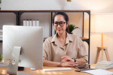 Mutluluk genç iş kadını masaüstü bilgisayarını evdeki oturma odasında kullanıyor, iş kadını internet, girişimci ya da serbest meslek ve iletişim için bilgisayar kullanıyor.