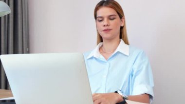 Kafkasyalı genç iş kadını akıllı telefonla konuşuyor ve ofisteki dizüstü bilgisayarda çalışıyor, iş kadını laptopta çalışıyor ve akıllı telefon, iş ve iletişim ile konuşuyor..