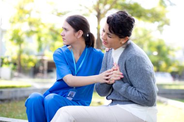 Beyaz kadın göğüs ağrısı, açık hava parkında ilk yardım hemşiresi, acil ve yaralı bir hasta, kadın ve yardım hastalığı, tıbbi ve kaza, hasta ve ifade bozuklukları.