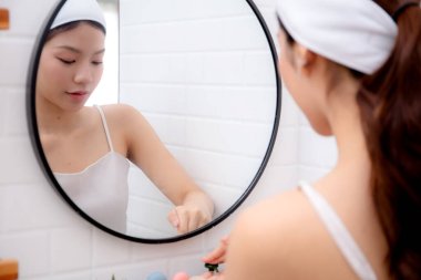 Evdeki banyoda sıvı sabun için genç Asyalı güzel kadın dağıtıcısı, temizlik için losyonla yıkanan kadın, hijyen ve sağlık, sağlık ve refah, güzellik ve yaşam tarzı.