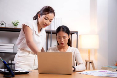 İki genç Asyalı iş kadını iş ortağı, iş ortağı ve danışmanlık ile dizüstü bilgisayar, toplantı ve çalışma arkadaşlarıyla pazarlama ve finans hakkında planlama ve strateji yapıyorlar..