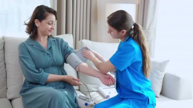 Bakıcı Kafkasyalı genç hemşire hastanın tansiyonunu ölçüyor nabız ölçümü ve evdeki oturma odasında muayene, sağlık, sağlık ve sigorta kontrolü.