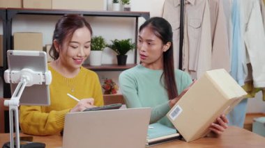 Çevrimiçi iş planlarken çalışan iki genç Asyalı kadın ve evde tablet ile sipariş kontrolü, çevrimiçi satıcı ile perakende satış, girişim işi ve kargo, nakliye ve hizmet.