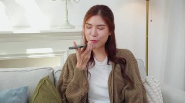 Genç Asyalı bir kadın akıllı telefonda sohbet botai ile konuşuyor, akıllı telefondan yapay zeka, asistanla ve iş kadınına danışmak, telefonda konuşan iş kadını..