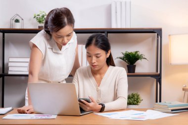 İki genç Asyalı iş kadını, iş ortağı, iş ortağı ve danışmanlık ile dizüstü bilgisayar ve tablet arayan iş arkadaşları ile pazarlama ve finans hakkında planlama ve strateji yapıyor..