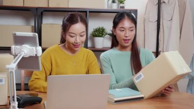 İki Asyalı kadın online iş planlarken ve evde dijital tabletle siparişi kontrol ederken, çevrimiçi satıcı ile perakende satış, girişim işi ve kargo, nakliye ve hizmet, küçük işletme.