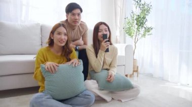 Asyalı grup arkadaşları korku ve sürprizle dolu bir korku filmi izliyorlar. Evdeki rahat bir oturma odasında birlikte oturuyorlar. Duygular, keyif alma, televizyon izlerken ifade verme..