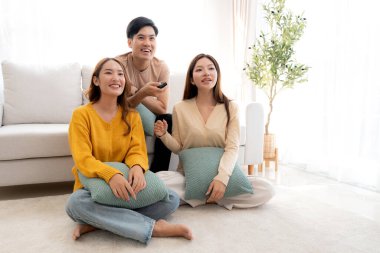 Bir grup Asyalı genç arkadaş evlerinde rahat bir oturma odasında birlikte televizyon izliyor, gülüyor ve eğleniyorlar. Televizyon izliyorlar, hem de rahat, yaşam tarzı ve eğlence ile..