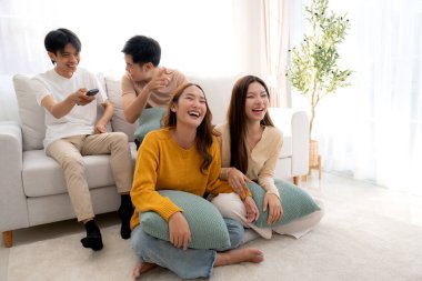 Bir grup Asyalı genç arkadaş evlerinde rahat bir oturma odasında birlikte televizyon izliyor, gülüyor ve eğleniyorlar. Televizyon izliyorlar, hem de rahat, yaşam tarzı ve eğlence ile..