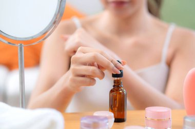 Kapalı eller güzel genç kadın losyon sürüyor evde aynaya bakıyor, güzellik kadın düşürücü serumu ellerinde gençleşme, kozmetik ve makyaj kişisel bakım, cilt bakımı ve sağlık için.