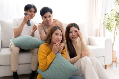 Asyalı grup arkadaşları korku ve sürprizle dolu bir korku filmi izliyorlar. Evdeki rahat bir oturma odasında birlikte oturuyorlar. Duygular, keyif alma, televizyon izlerken ifade verme..