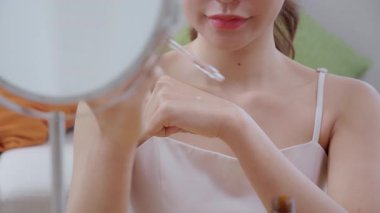 Kapalı eller güzel genç kadın losyon sürüyor evde aynaya bakıyor, güzellik kadın düşürücü serumu ellerinde gençleşme, kozmetik ve makyaj kişisel bakım, cilt bakımı ve sağlık için.